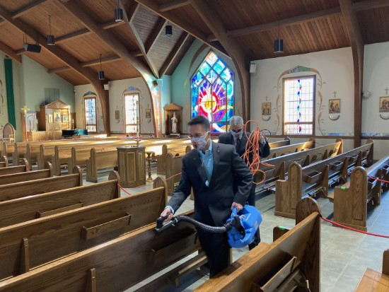 Knights help disinfect the church pews